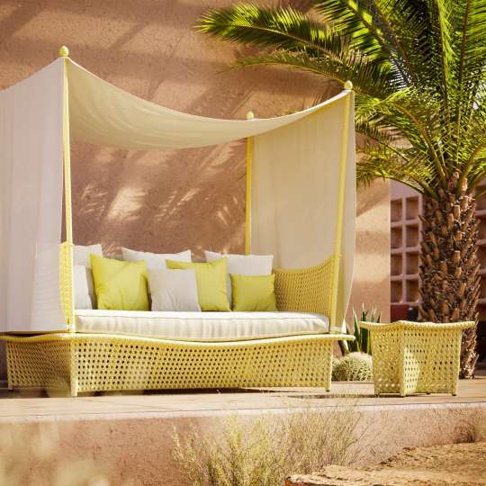 Ein Daybed – hier mit Baldachin und Wiener Geflecht – bietet eine besonders behagliche Möglichkeit zum Entspannen im Freien. Foto: VDM/Dedon